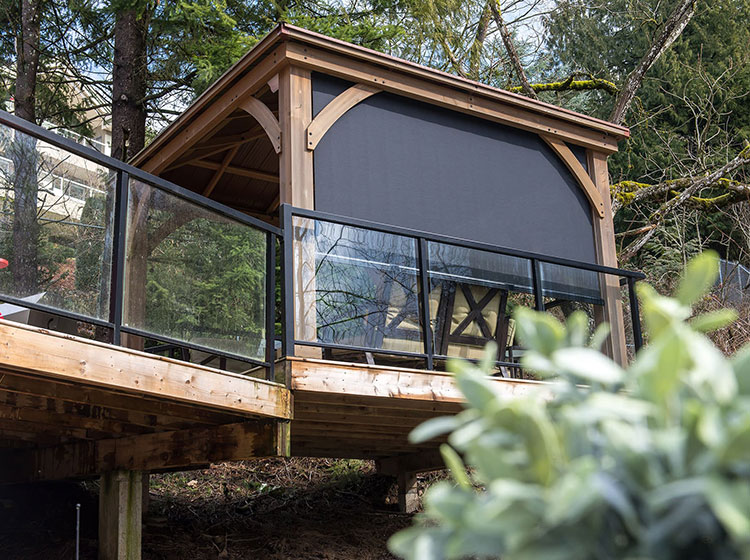 Elevated wooden pergola with cable-guided screens and glass railing, showcasing modern outdoor living space